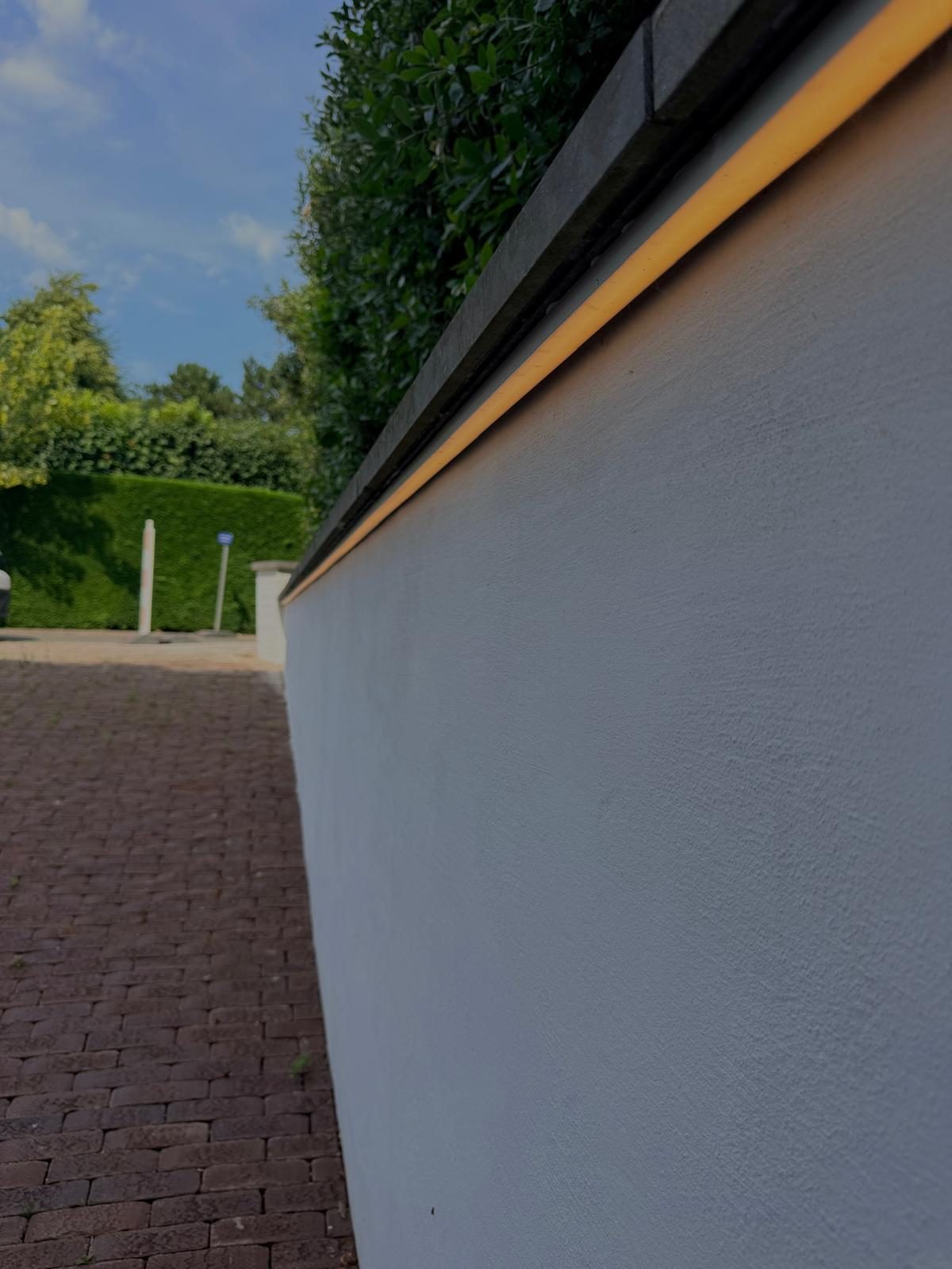Ledlijn op een tuinmuur bij schemering